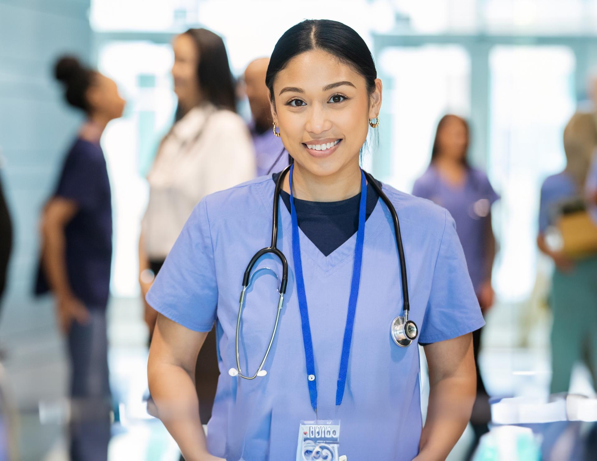 Female nurse wearing blue scrubs.