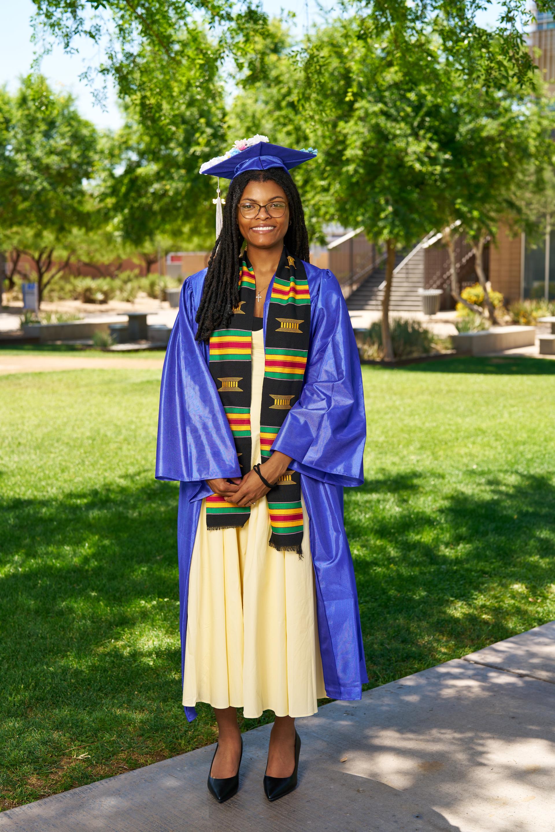 Temya poses on campus in her cap and gown