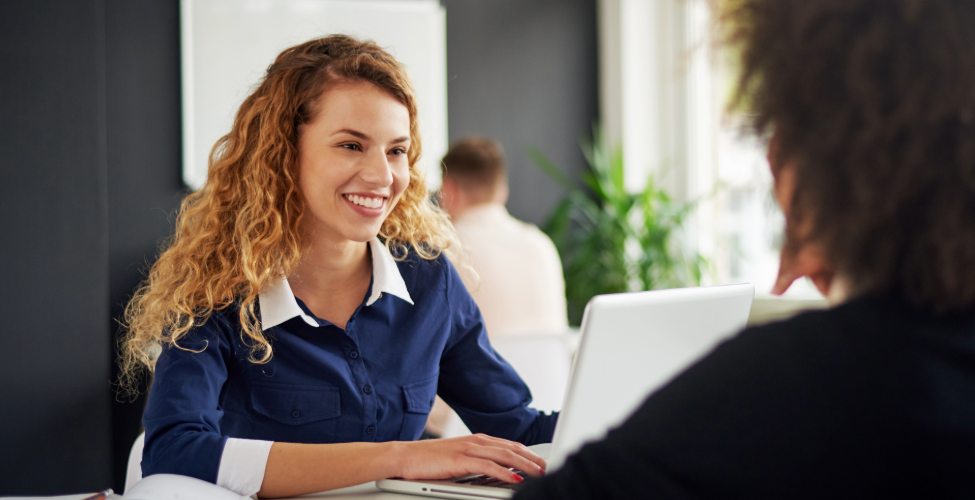 Woman sitting at table with silver laptop
