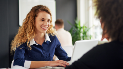 Woman sitting at table with silver laptop