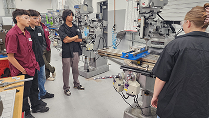 Group of students looking at CNC machine