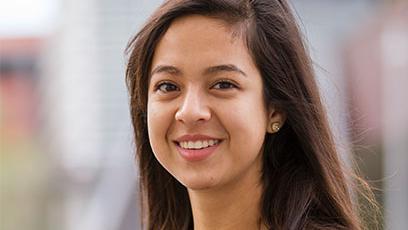 Brenda Perez stands poses in front of the IE building at the GateWay Washington campus