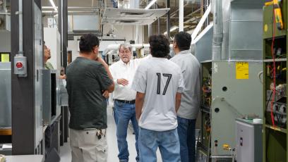 An HVAC instructor gives a tour of the GateWay HVAC lab to four potential students.