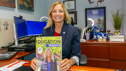 Dr. Amy Diaz smiles with a copy of GateWay on the cover of Education Insider magazine