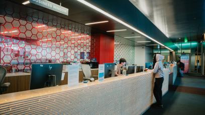 A student talks to a GateWay staff member at the enrollment desk in the IE Building on campus. 