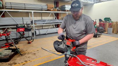 GateWay Student Robert Holcomb demonstrates electrical machinery while wearing a hat and safety glasses. 