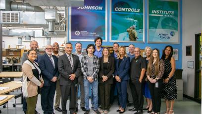 The group of students, JCI representatives, GateWay administration, and local leaders post in front of the new JCI sign in the HVAC lab. 