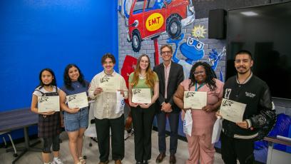Students gather with their certificates after reading their writing submissions