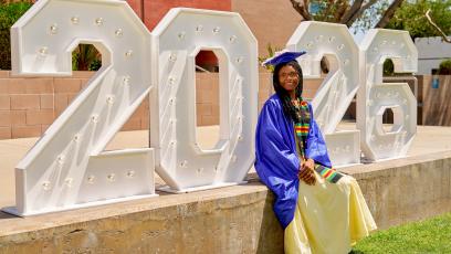 Temya Jackson Long wears her cap and gown in front of 2026 numbers display