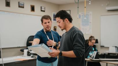 A student discusses a topic with his instructor in a healthcare class