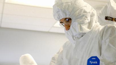 A student wears an all-white bunny suit to enter a clean room for semiconductor training. 