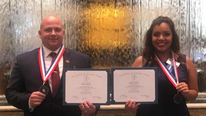 Male and female students posing with academic medals