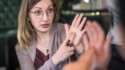 Woman sitting down speaking to another person