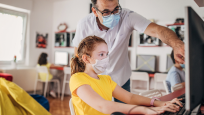 Image of man helping child at computer 