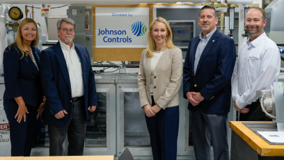 GateWay President Dr. Amy Diaz (far left) and GateWay HVAC Program Director Bruce Martz (middle left) stand with three members of Johnson Control Industries, with a banner reading "Donated by Johnson Controls" hanging in the middle of the group.