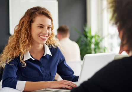 Woman sitting at table with silver laptop