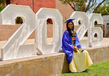 Temya Jackson Long wears her cap and gown in front of 2026 numbers display