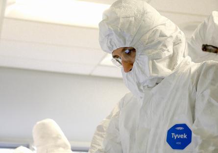 A student wears an all-white bunny suit to enter a clean room for semiconductor training. 