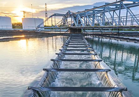 Water flowing outdoors through a water processing plant as the sun sets.