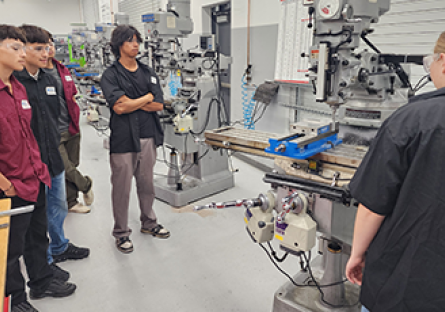 Group of students looking at CNC machine