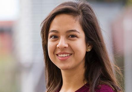 Brenda Perez stands poses in front of the IE building at the GateWay Washington campus