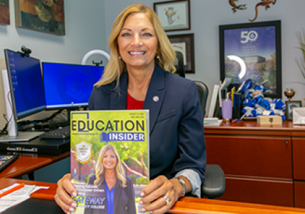 Dr. Amy Diaz smiles with a copy of GateWay on the cover of Education Insider magazine