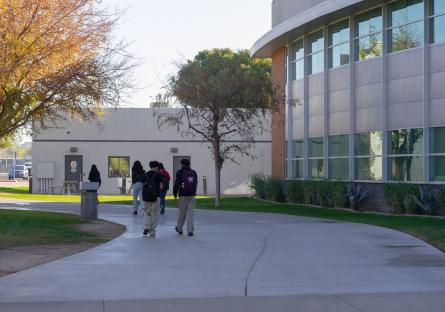 Several students walk through campus on a sidewalk at GateWay