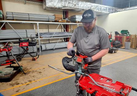 GateWay Student Robert Holcomb demonstrates electrical machinery while wearing a hat and safety glasses. 