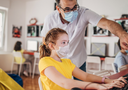 Image of man helping child at computer 