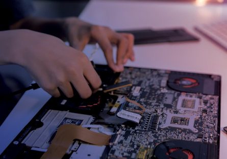 Image of hands working on a computer internal board
