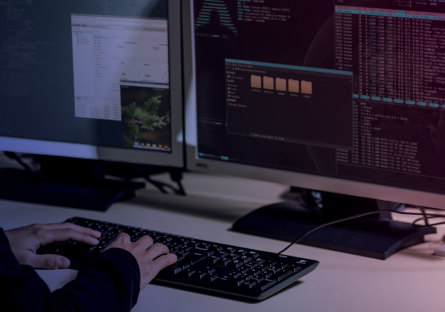 Hands at a computer with code on the screen