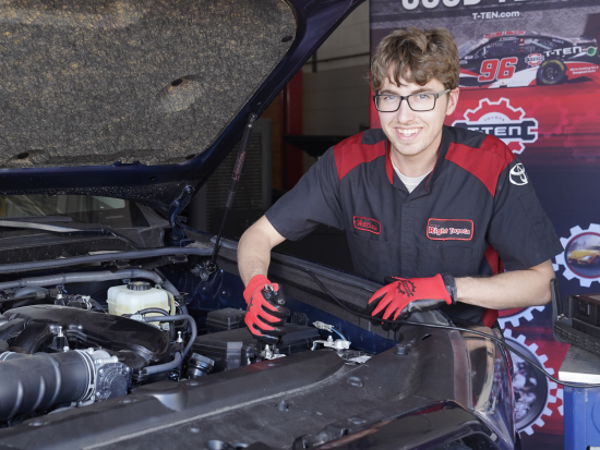 Male student working under hood of car