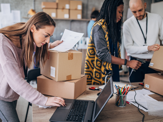 Workers packing orders in cardboard boxes