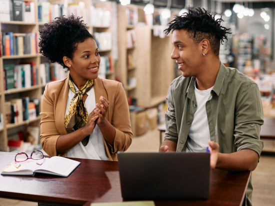 Male and female sitting next to each other in the library