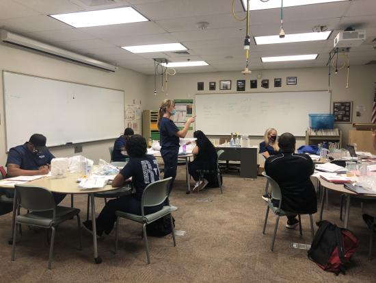 Professor talking to their students sitting down