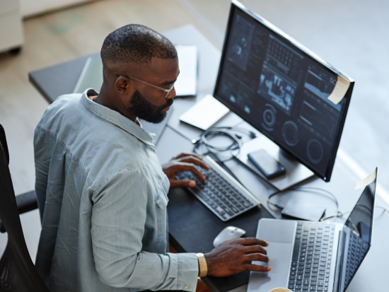 Man sitting at computer looking at graphs
