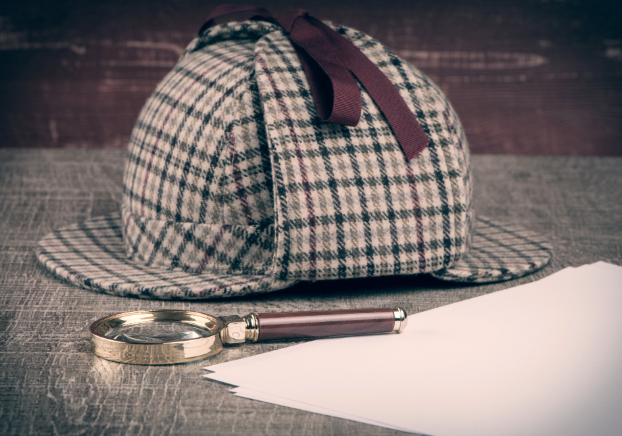 Plaid hat and magnifying glass sitting on table