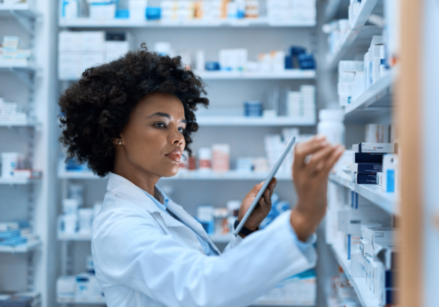 A pharmacy technician looking at a bottle of medicine.