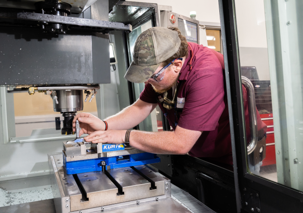 Male student working in a CNC machine