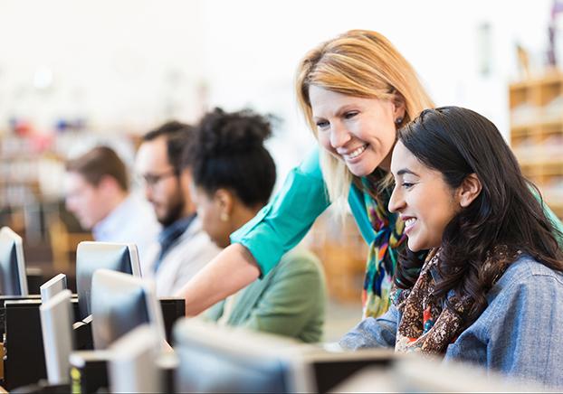 A librarian helping out a student on the computer