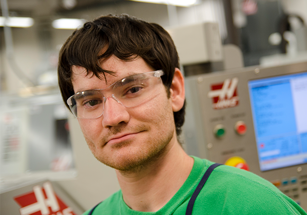 Male wearing clear work glasses smiling at camera