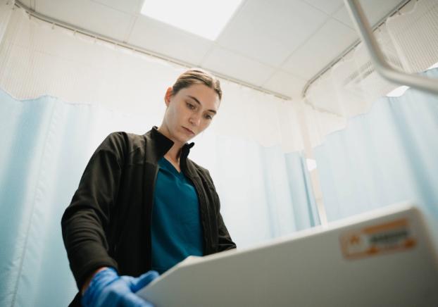 Healthcare student in a clinical lab setting reviewing medical equipment