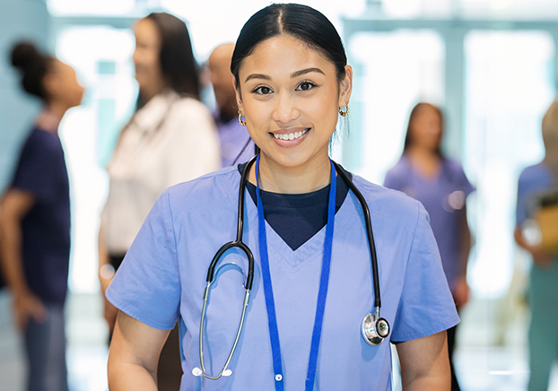 Woman wearing light blue scrubs and a stethoscope around her shoulders