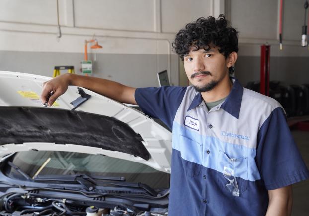 Automotive technology student working on a vehicle engine.