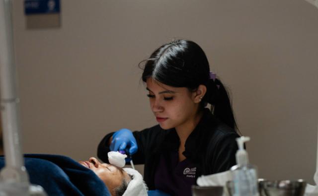 Student performing a professional manicure in a salon lab