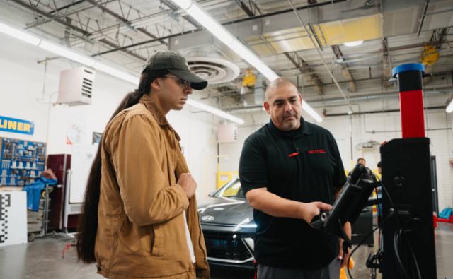 Instructor and student reviewing automotive diagnostic equipment